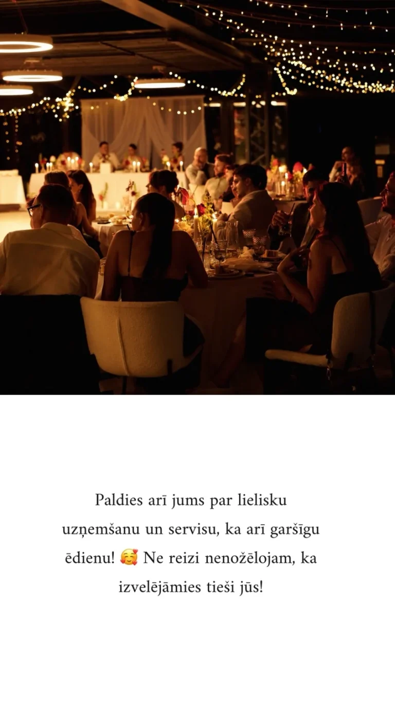 Kāzu viesi vakarā pie galdiem ar svecēm un gaismas virtenēm Miró restorāna terasē